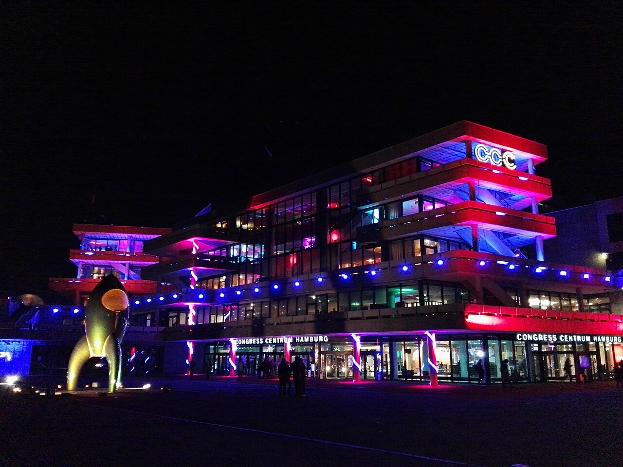 Besucher des 33. Chaos Communication Congress im Congress Center Hamburg bei Nacht, blau beleuchtet.