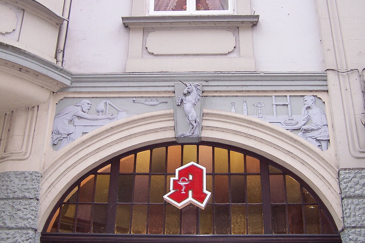 Grünes Apothekenschild mit dem stilisierten Apotheken-A vor einer deutschen Apotheke in Oldenburg.