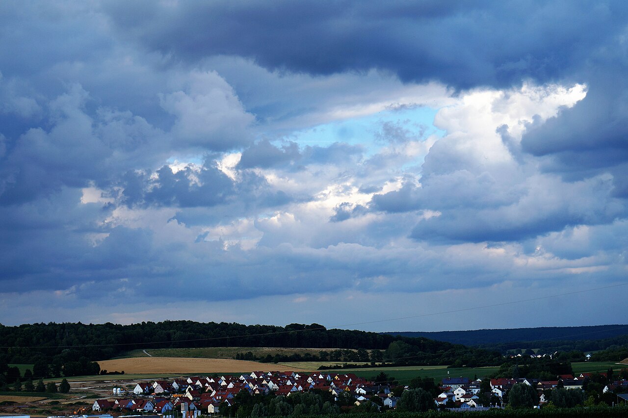 Dunkle Gewitterwolken ziehen über eine Landschaft in Bayern zusammen