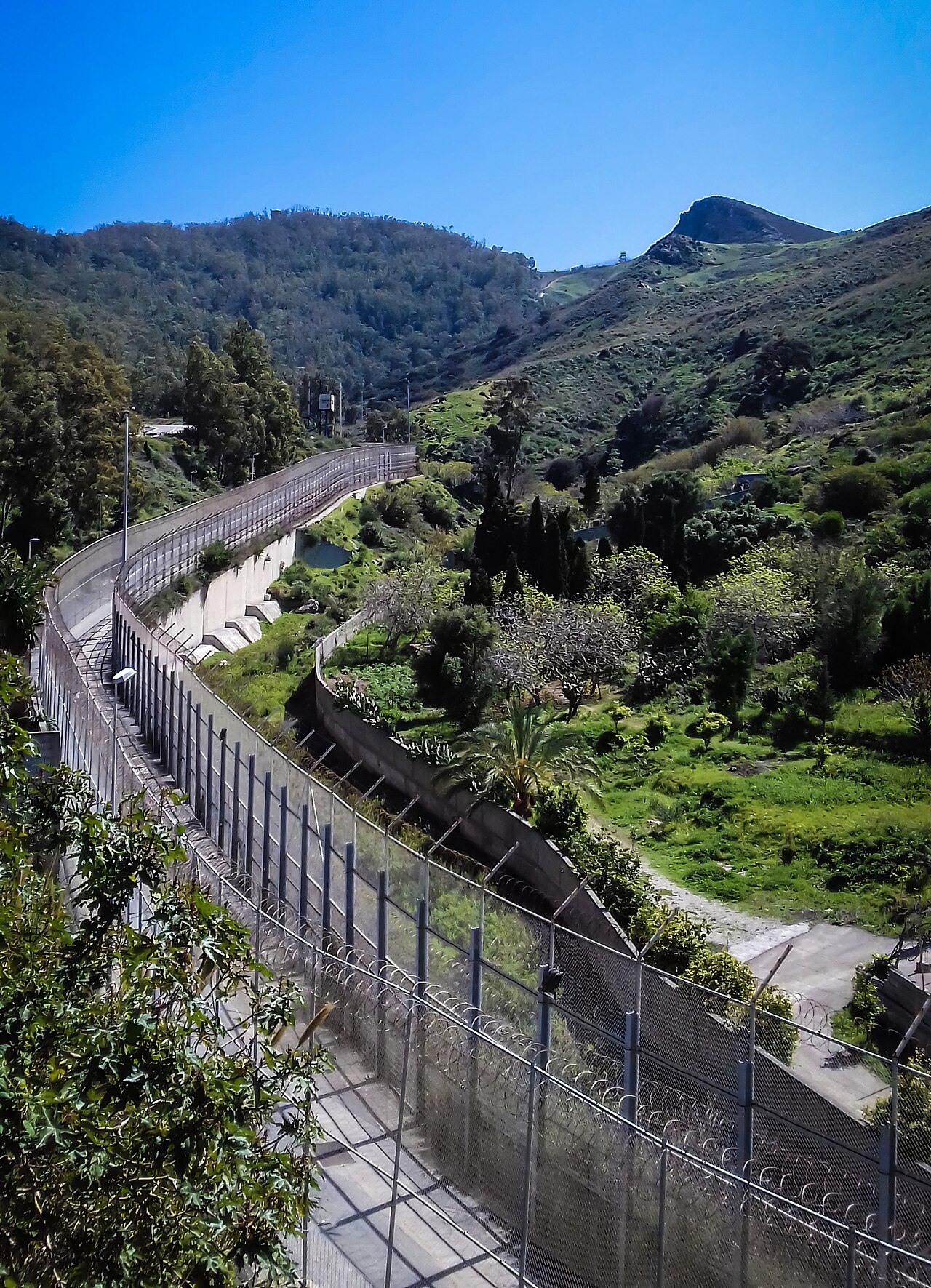 Der doppelte Grenzzaun zwischen der spanischen Exklave Ceuta und Marokko, Blick von der spanischen Seite nach Süden.