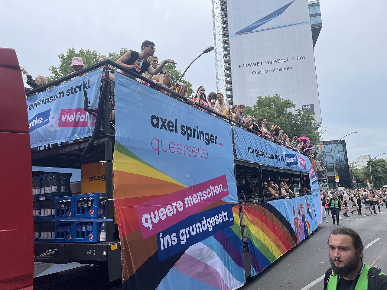 Teilnehmende beim Christopher Street Day in Berlin mit Regenbogenfahnen.