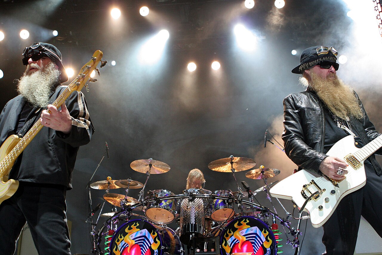 ZZ Top live auf der Bühne, Billy Gibbons und Dusty Hill vorne, Frank Beard am Schlagzeug im Hintergrund