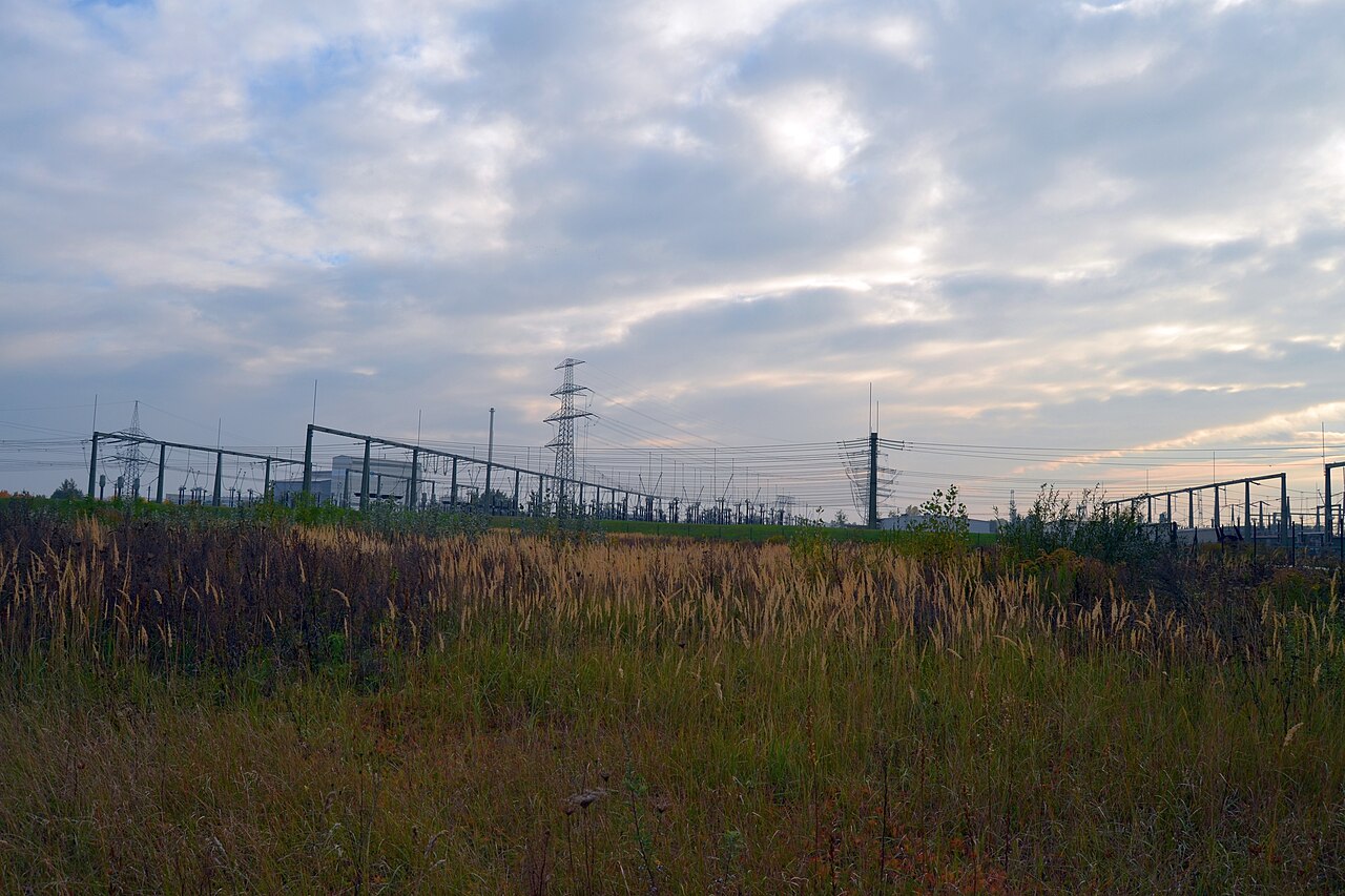 Hochspannungs-Schaltanlage mit Masten und Isolatoren im Abendlicht