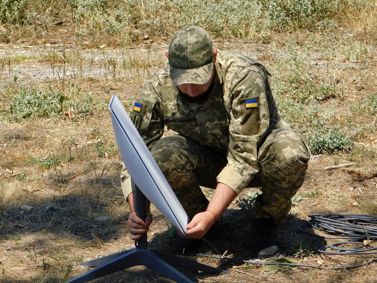 Ein ukrainischer Soldat der Support Forces installiert ein Starlink-Terminal im Feld.