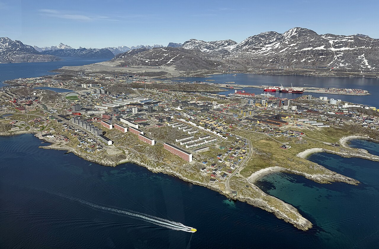 Luftaufnahme der grönländischen Hauptstadt Nuuk mit farbigen Wohnhäusern am Fjord.