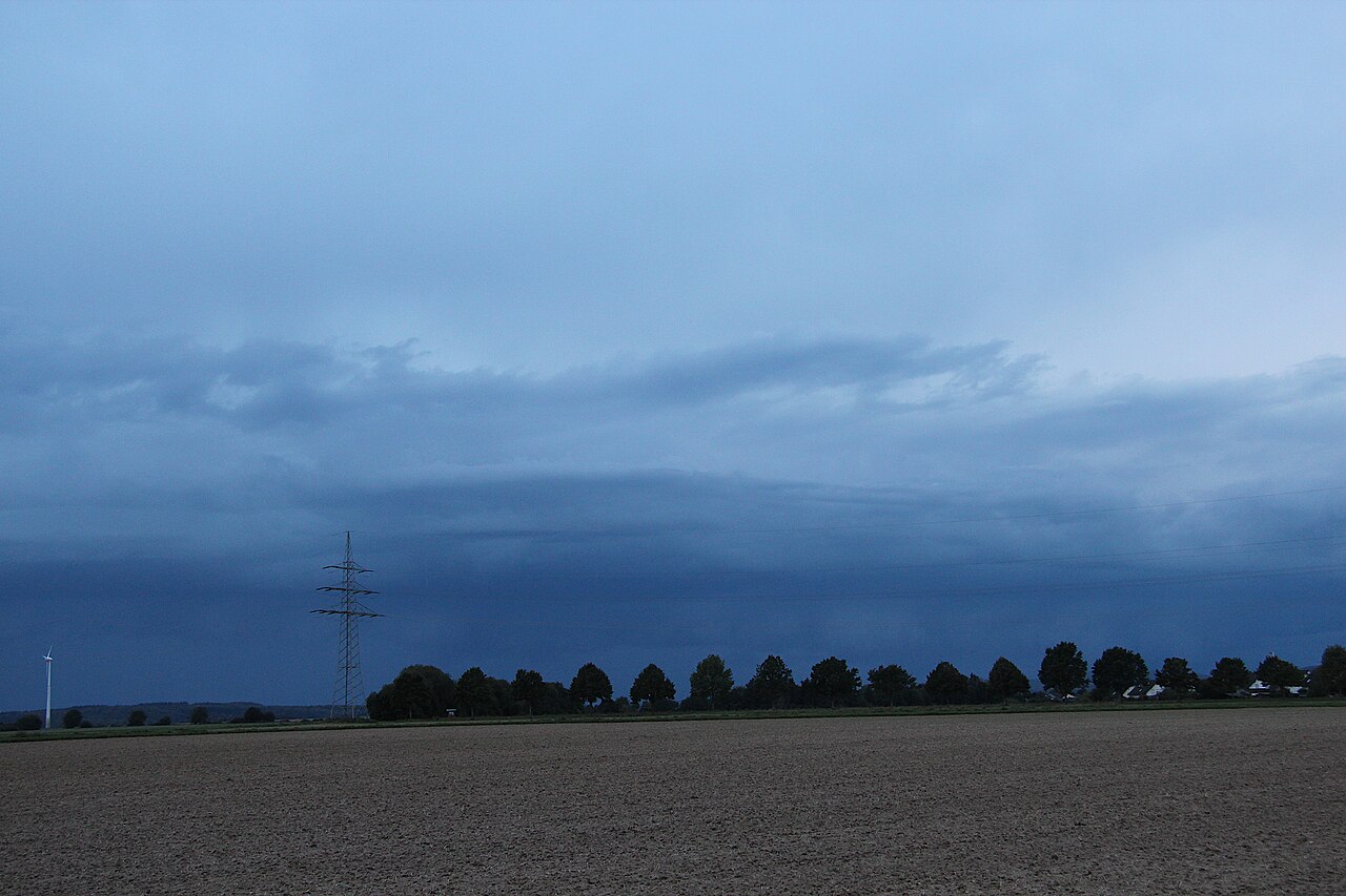 Ein Cumulonimbus arcus, eine Böenfront aus dunklen Wolken, schiebt sich über die Landschaft bei Limburg an der Lahn.