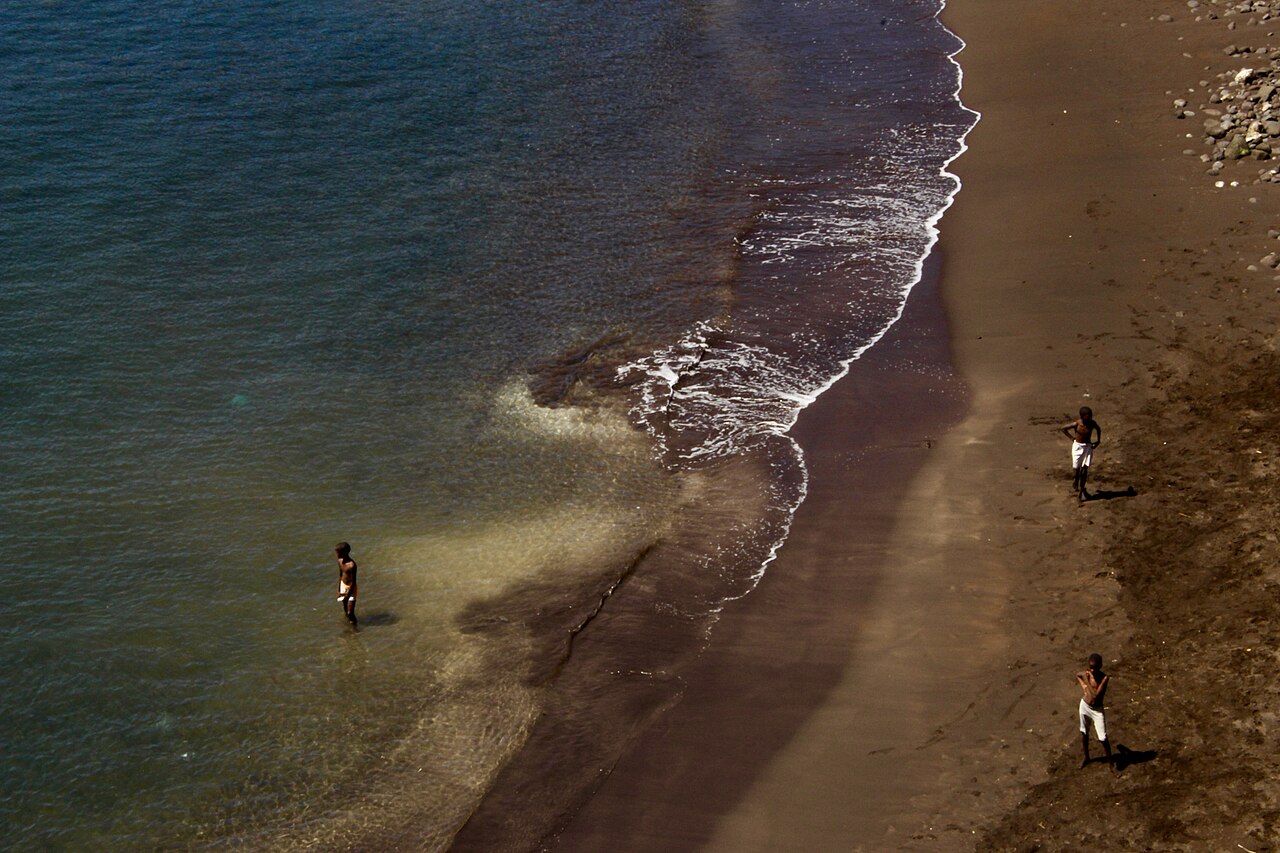 Jungen spielen Fußball an einem schwarzen Strand in Cidade Velha auf Kap Verde